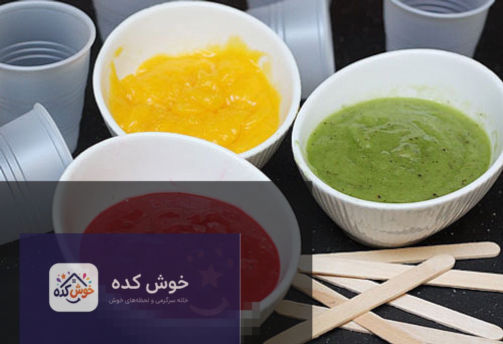 بستنی یخی سه رنگ با طعم های مختلف نمای نزدیک از بستنی یخی سه رنگ میوه ای در لیوان شیشه ای، با لایه های توت فرنگی، انبه و کیوی