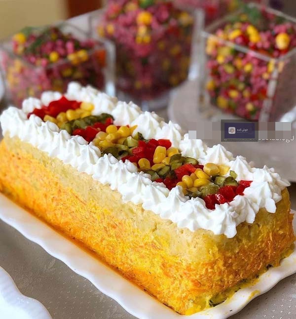 کیک سیب زمینی و هویج مجلسی با تزیین جعفری تازه و سس مایونز، برش خورده و آماده سرو روی میز چوبی