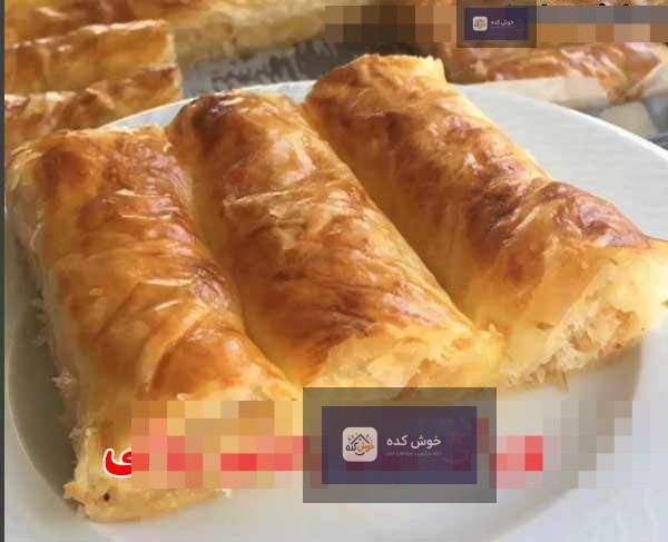 بورک سیبزمینی رولی ترد و خوشمزه بورک سیبزمینی رولی طلایی و برشته، چیده شده در سینی فر، آماده سرو به عنوان پیشغذایی شیک و لذیذ