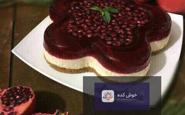 چیز کیک انار با دانه‌های قرمز و براق انار، مناسب برای شب یلدا، تزئین شده با برگ‌های نعناع تازه