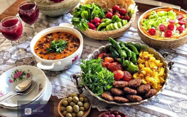 میز شام چیده شده با انواع غذاهای ایرانی و خارجی برای مهمانی و دورهمی