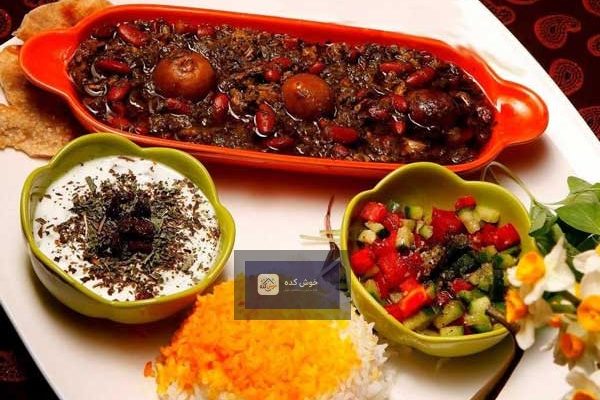 خورشت قورمه سبزی جا افتاده با گوشت و سبزی تازه، سرو شده در ظرف سنتی با برنج زعفرانی