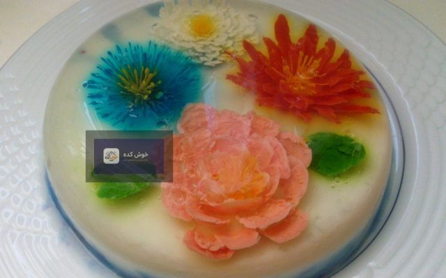 ژله تزریقی با طرح گل‌های رنگارنگ و برگ‌های سبز در ظرف شیشه‌ای شفاف