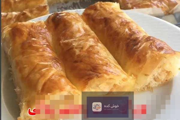 بورک سیب‌زمینی رولی طلایی و برشته، چیده شده در سینی فر، آماده سرو به عنوان پیش‌غذایی شیک و لذیذ