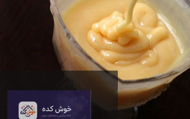 شیر عسلی خانگی غلیظ و خوشمزه در یک کاسه شیشه ای با قاشق، آماده سرو