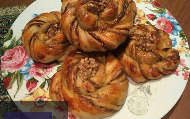 نان خرمایی تازه پخته شده با کنجد روی سینی چوبی، مناسب برای افطار ماه رمضان