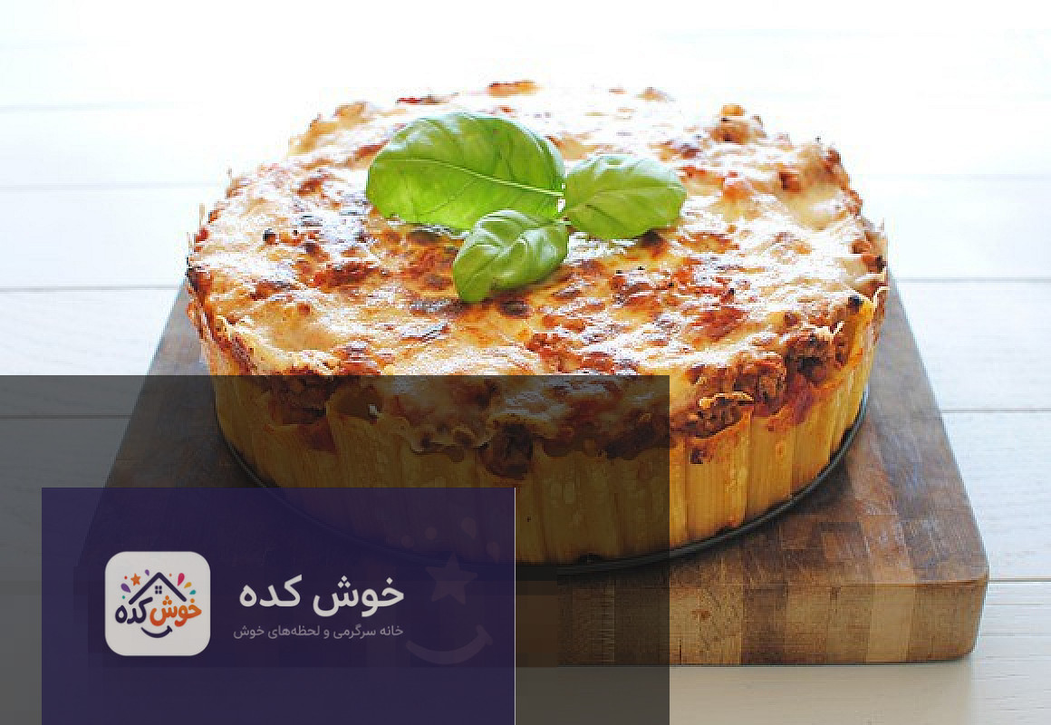 پاستا قالبی خوشمزه با سس مخصوص پاستا قالبی (کیک پاستا) با سس مخصوص و سبزیجات تازه، آماده سرو در ظرف سفید