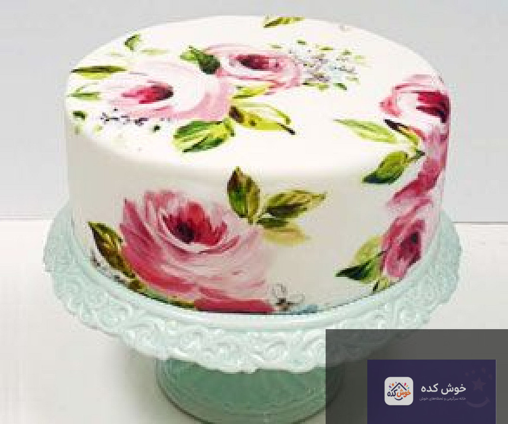 کیک فوندانت سفید با نقاشی دستی طرح پروانه و گل‌های ظریف به رنگ‌های آبی و صورتی، مناسب برای تولد