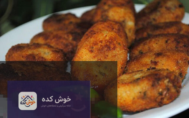 کتلت ماهی سرخ شده و طلایی با سبزیجات تازه و لیمو، آماده سرو در یک بشقاب زیبا