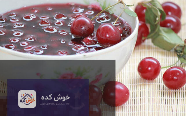 مربای آلبالوی خانگی در ظرف شیشه ای با آلبالوهای تازه کنار آن، آماده سرو