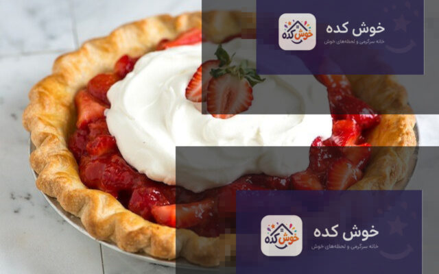 پای توت فرنگی خانگی با رویه طلایی و برش خورده، آماده سرو روی میز چوبی