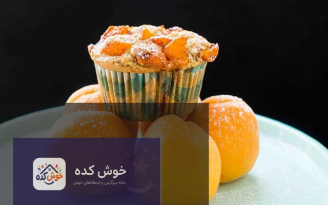 مافین زردآلو تازه پخته شده با تکه‌های زردآلو روی سینی چوبی، آماده سرو