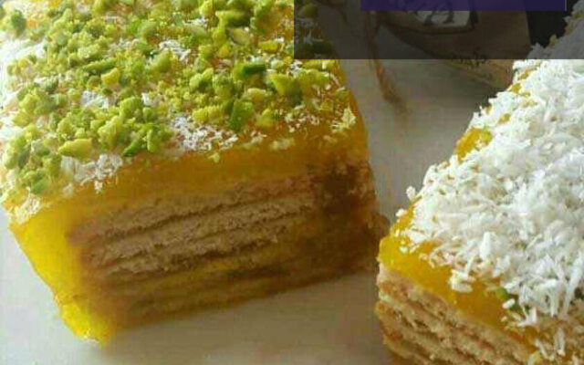 دسر مسقطی زعفرانی با بیسکویت پتی بور، مناسب برای افطار و مهمانی ها، با تزیین خلال پسته و گل محمدی