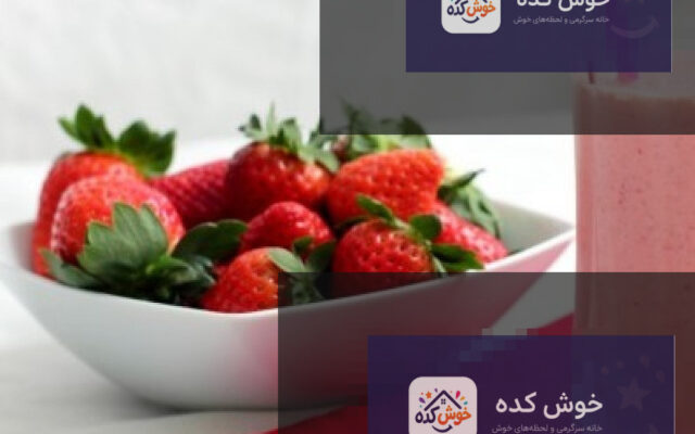 شیر موز با توت فرنگی در لیوان بلند، تزئین شده با توت فرنگی و برگ نعنا، در پس زمینه میوه های تازه