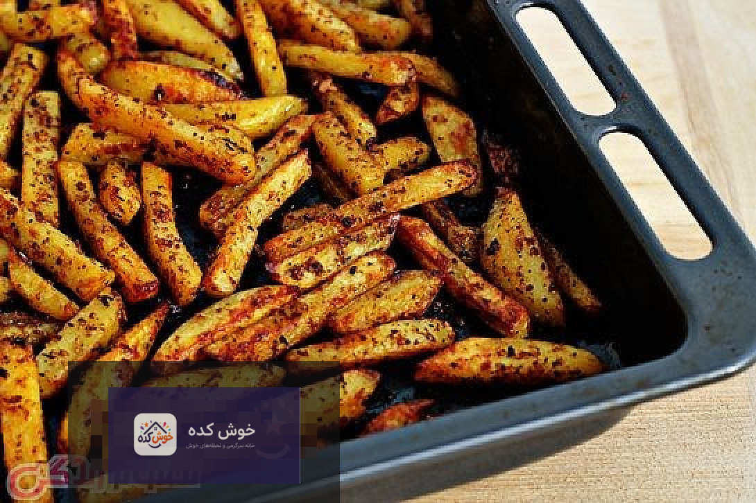 سیب زمینی تنوری تند و طلایی در سینی فر، آماده برای سرو، با ادویه‌های رنگارنگ روی آن