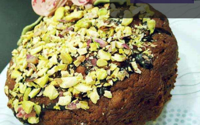 کیک خرما و پسته تازه پخته شده با رویه پسته خرد شده و خرما، مناسب برای ماه رمضان