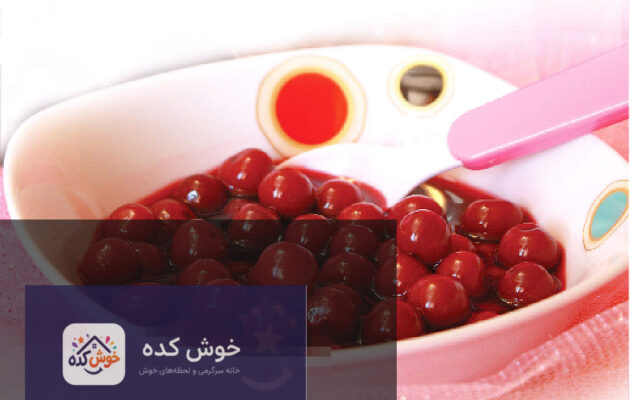 ترشی آلبالو خانگی خوشرنگ در ظرف شیشه ای با زمینه چوبی، آماده سرو
