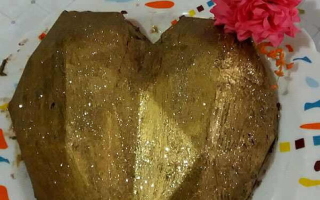 شکلات قلبی سورپرایز با روکش قرمز براق، تزیین شده با پودر طلایی و مرواریدهای خوراکی، مناسب ولنتاین