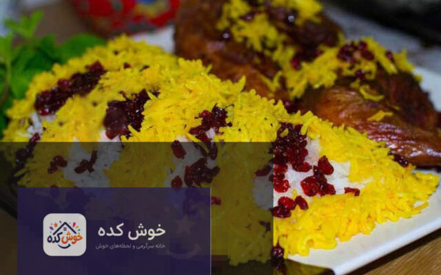 زرشک پلو با مرغ مجلسی و زعفرانی آماده سرو در دیس، تزیین شده با خلال پسته و بادام