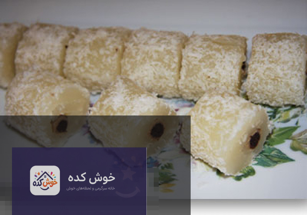 مسقطی بیسکویتی با لایه های سفید و قهوه ای، تزیین شده با پودر پسته و گل محمدی، آماده سرو در ظرف شیشه ای
