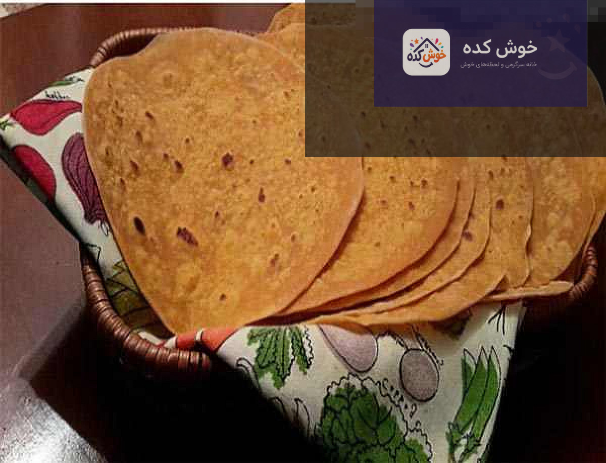 نان کشتا گیلانی تازه پخته شده با رویه طلایی و کنجد، برش خورده و آماده سرو