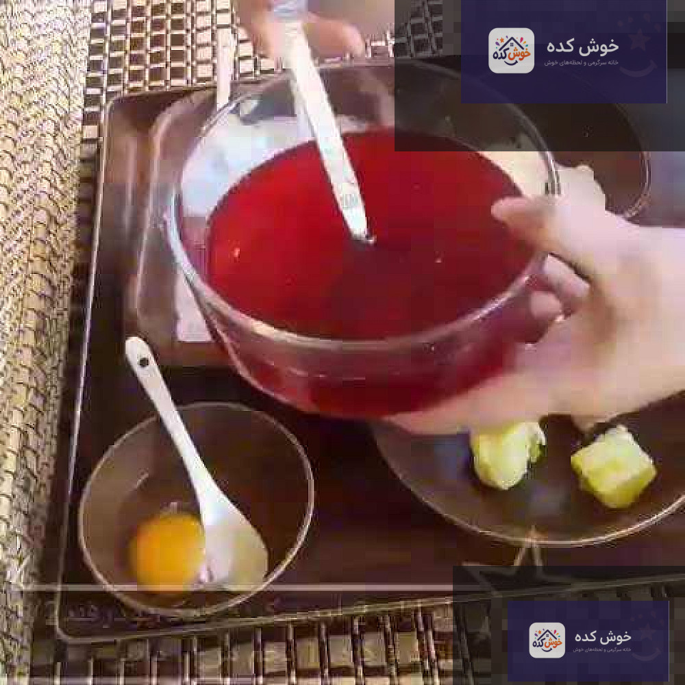 برش خورده تارت انار با لایه‌های کرم و دانه‌های انار، روی میز چوبی