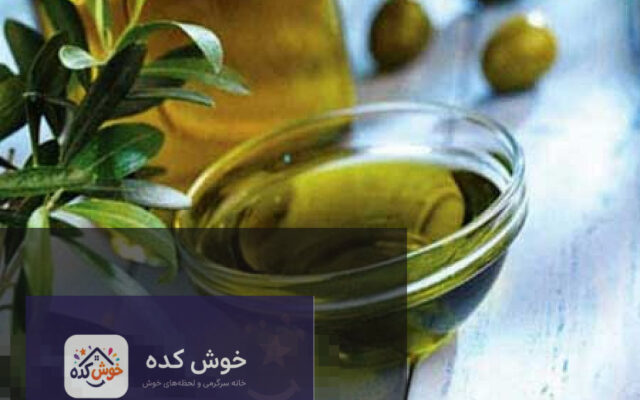 روغن زیتون خالص در یک بطری شیشه‌ای در کنار برگ‌های زیتون تازه، نشان‌دهنده فواید طبیعی برای پوست و مو.