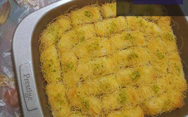 کنافه رولی با پنیر، دسری خوشمزه و اصیل، آماده سرو در ظرف چوبی