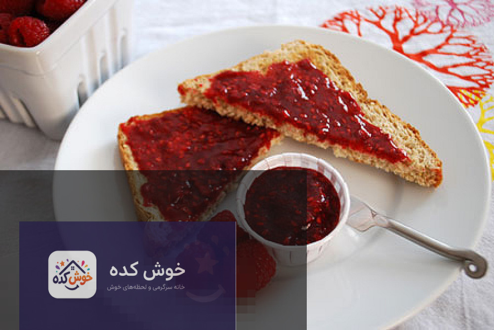 مربای تمشک خوش طعم مربای تمشک تازه و خوشرنگ در کاسه شیشهای، آماده برای سرو در ماه رمضان