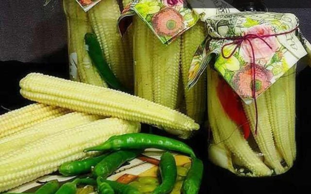 ترشی بچه بلال خانگی در ظرف شیشه ای با سبزیجات معطر و فلفل، آماده سرو