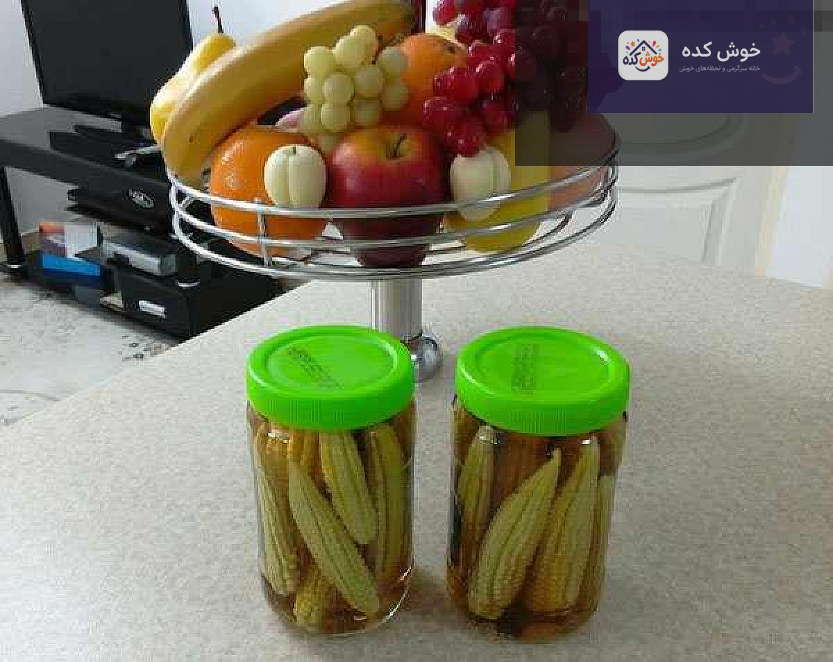 بچه بلال های تازه و آماده برای تهیه ترشی، چیده شده در کنار سبزیجات و ادویه جات
