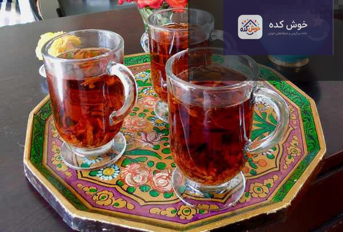 دمنوش به در قوری شیشه‌ای در حال دم کشیدن، با بخار ملایم و رنگ کهربایی زیبا