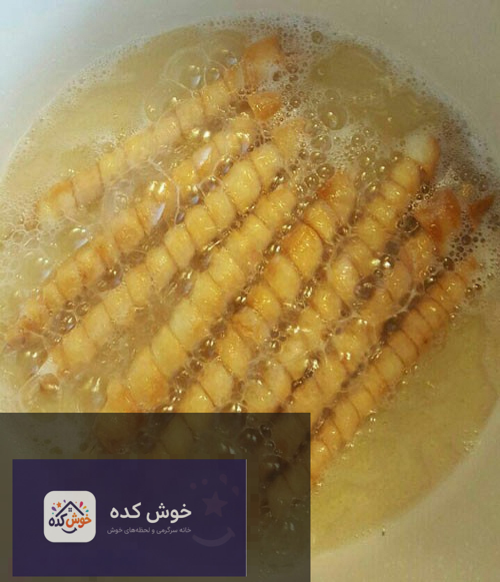 برش خاگینه سیگارتی: بافت داخلی و شربت نمای نزدیک از خاگینه سیگارتی برش خورده، با بافت داخلی نرم و شربت شیرین روی آن
