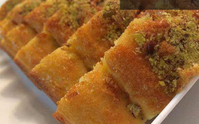خاگینه قالبی طلایی و پف‌دار در فر، آماده سرو با تزئین پودر پسته و گل محمدی