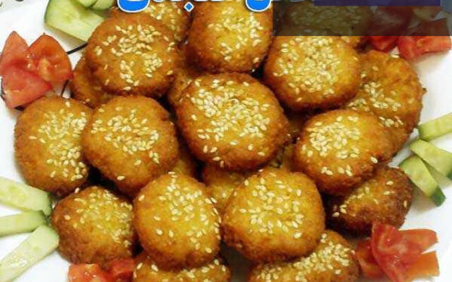 فلافل کنجدی طلایی و برشته با سس مخصوص در کنار سبزیجات تازه