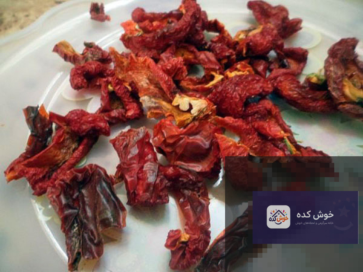 برش‌های فلفل دلمه‌ای قرمز در حال خشک شدن روی سینی مشبک برای تهیه پودر پاپریکا