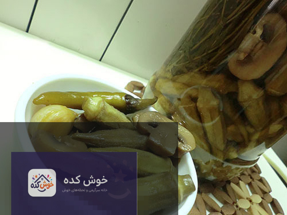 ترشی بامیه و قارچ نمای نزدیک از ترشی بامیه و قارچ در ظرف شیشه ای با سیر و فلفل