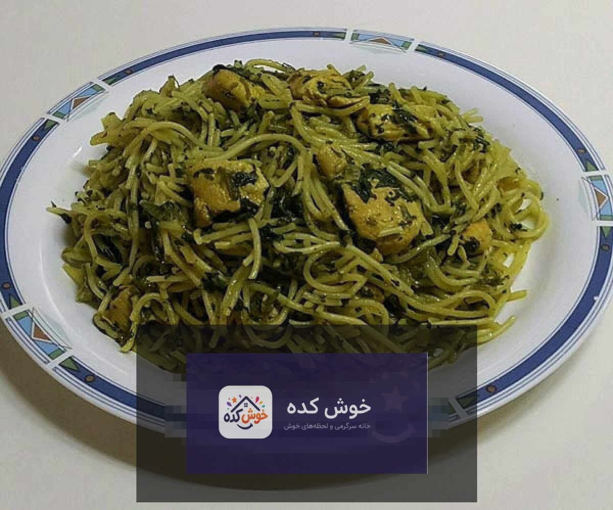 پاستا اسفناج با مرغ و سس خامه‌ای سبز، تزئین شده با جعفری تازه در بشقاب سفید