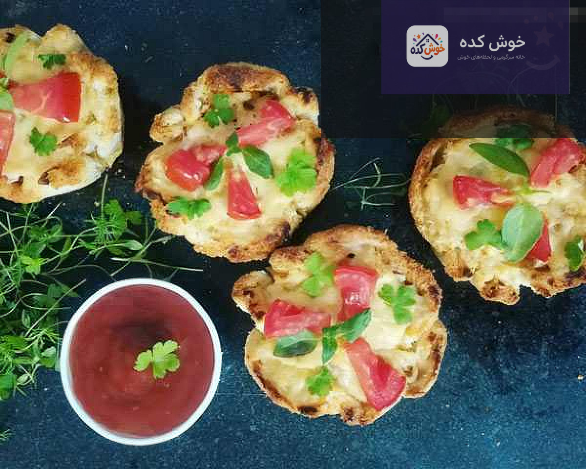 فینگر فود نان تست برای مهمانی سینی فینگر فود متنوع با نان تست، شامل برش های مثلثی و رول های کوچک با تزئینات رنگارنگ